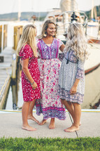 barefoot women standing on a boat dock at a marina 