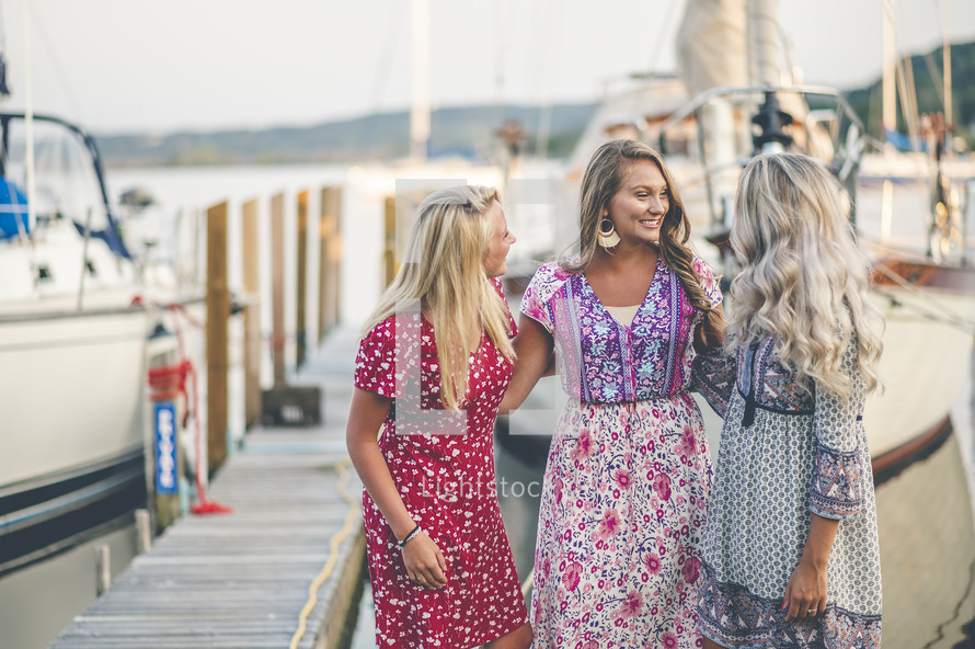 women standing on a boat dock at a marina 