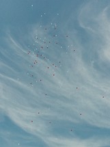 red and white helium balloon rising in the sky 