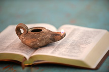 oil lamp on the pages of a Bible 