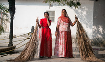 women sweeping in India with palm fronds 