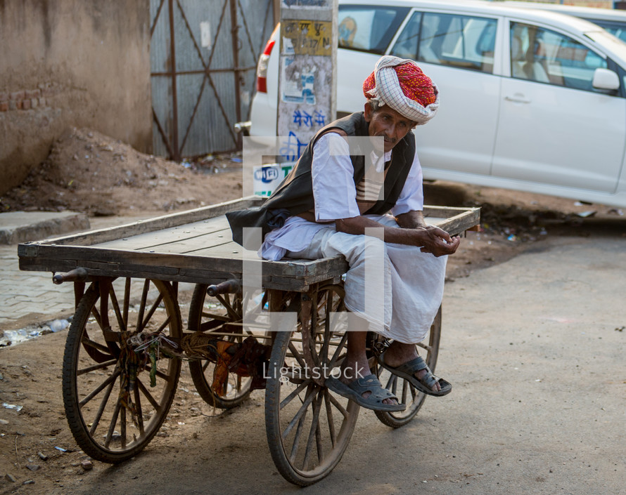 a man sitting on a cart in India 
