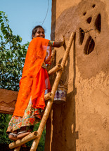 a woman painting a house in India 