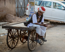 a man sitting on a cart in India 