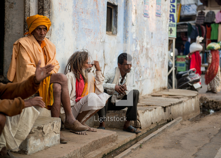 men sitting on the dusty streets of India 