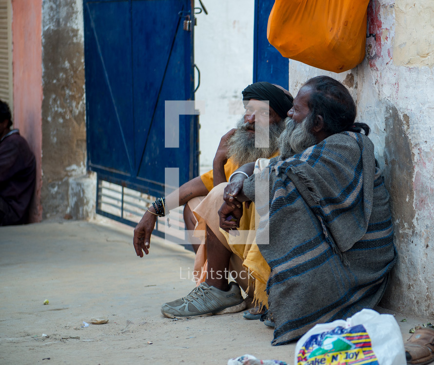 men in India sitting on a dusty street