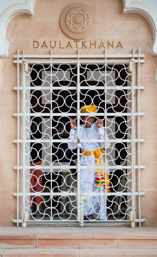 a man looking through a gate in India 