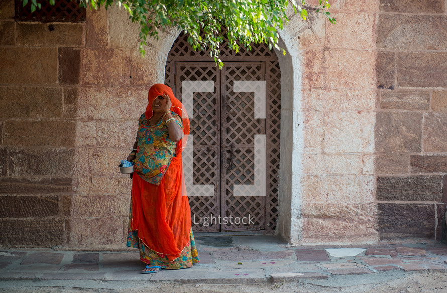 a woman on a sidewalk in India 