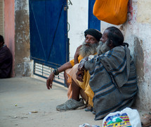 men in India sitting on a dusty street