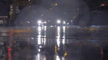 Cars with bright headlights in the city at rainy autumn night
