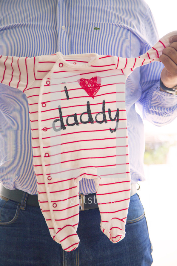 father holding an infant's clothes - l love daddy 