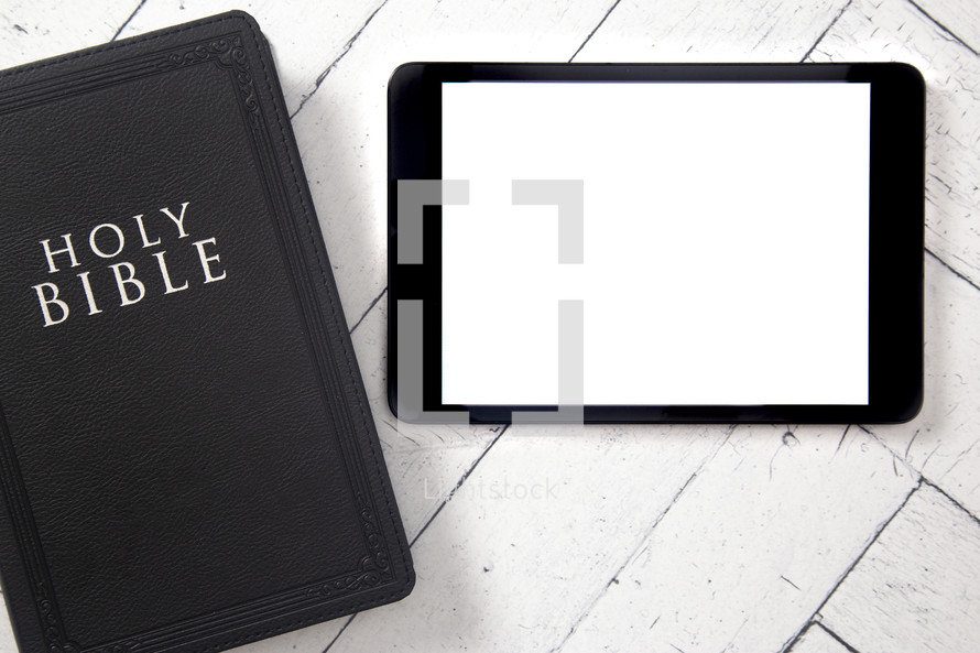 Bible and tablet on a white wood background 