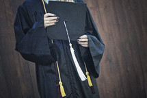 a teen girl holding a graduation cap 