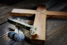 a small wooden cross and three nails 