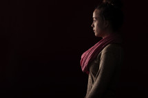 Side of a woman facing a light.