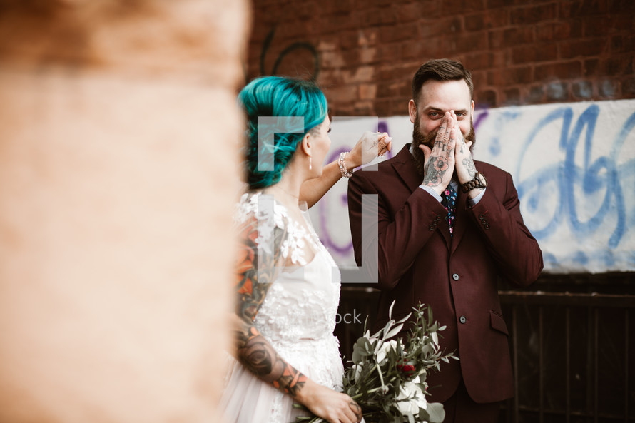 hipster bride and groom standing in an alley 