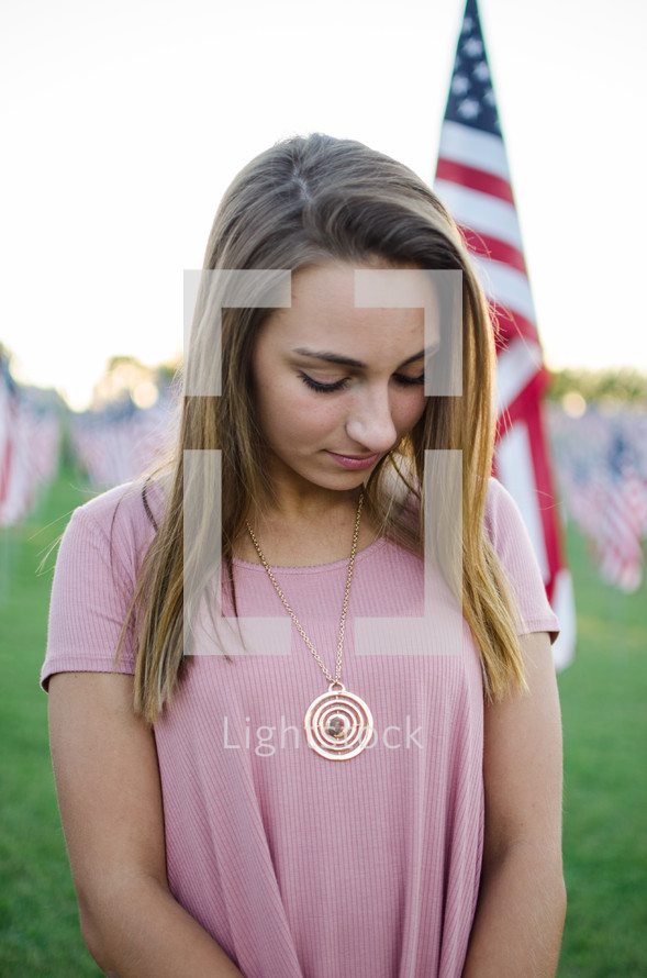 a woman praying near patriotic Valor Flags