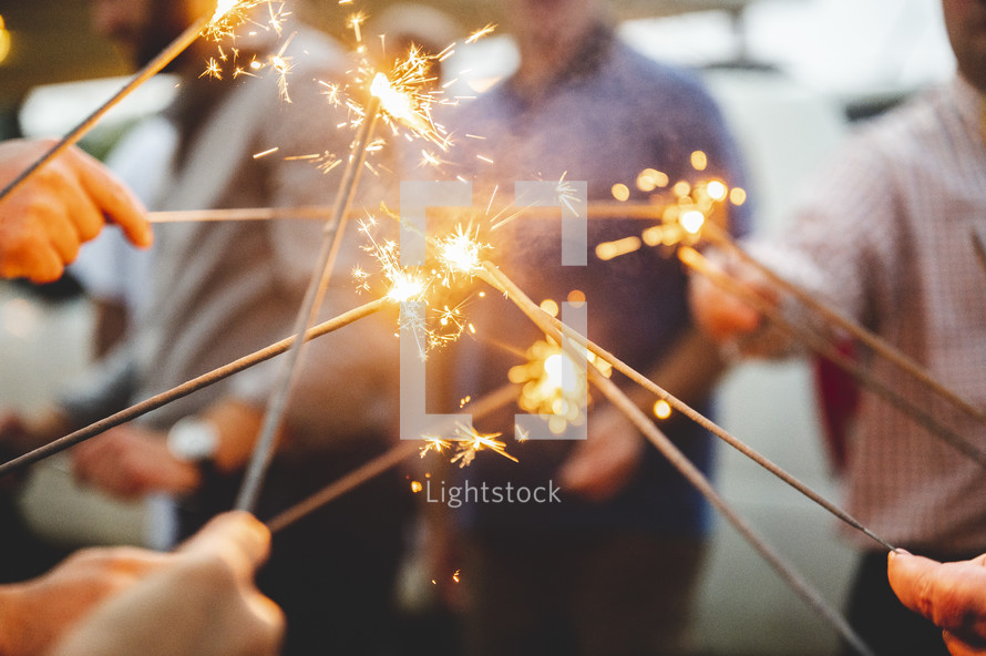 people holding sparklers at a wedding 