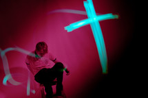 cross in lights in front of a man