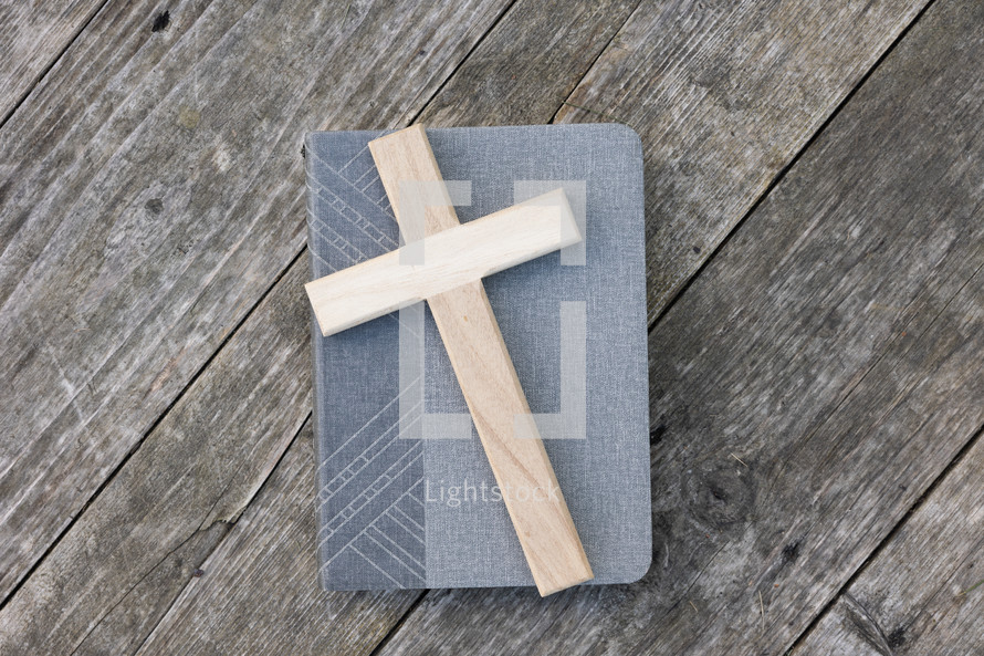 Cross on book and rustic wood