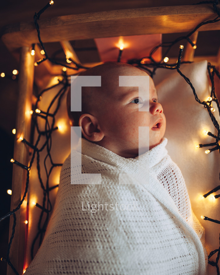 Christmas lights surrounding baby Jesus in the manger 