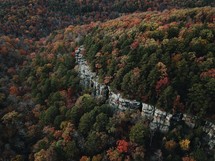 aerial view over a fall forest and cliffs