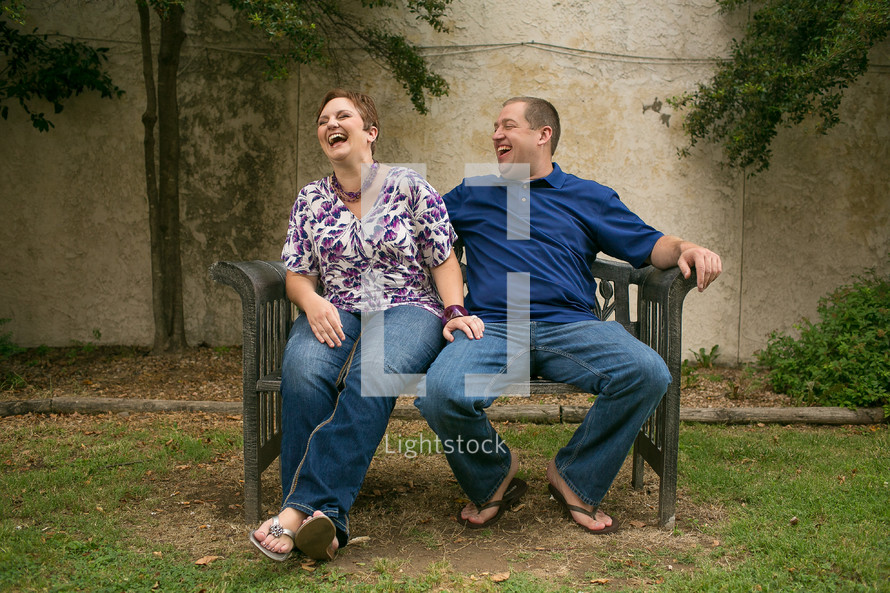 Man and woman laughing on a bench