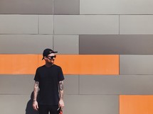 man standing in front of a gray and orange wall 