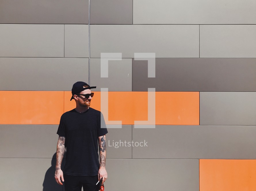 man standing in front of a gray and orange wall 