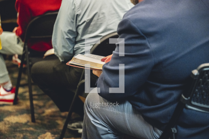 Man reading his Bible during a church service.
