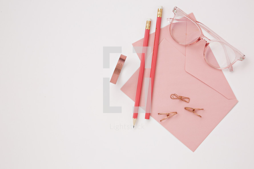 desk with pencils, stationary, clips, and reading glasses 