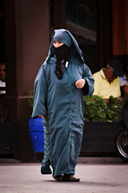 covered muslim woman walking on the streets 
