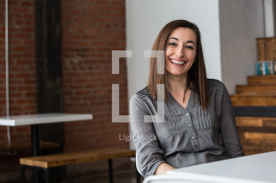 woman smiling sitting at a table 