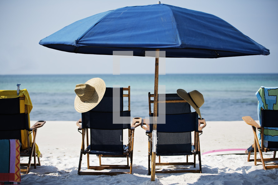 beach chairs under a beach umbrella 