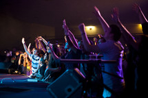 A group of young people lifting their hands in worship