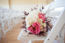 bridal bouquet on a white folding chair