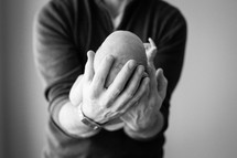 a father holding a newborn in his hands 