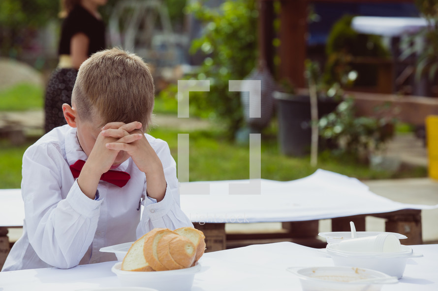 child praying before his meal 