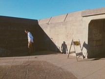 A man standing near concrete walls.