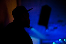 silhouette of a man in a hat at a concert