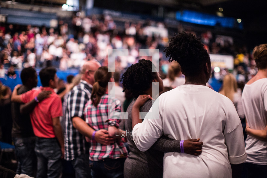 arms around each other during a worship service 