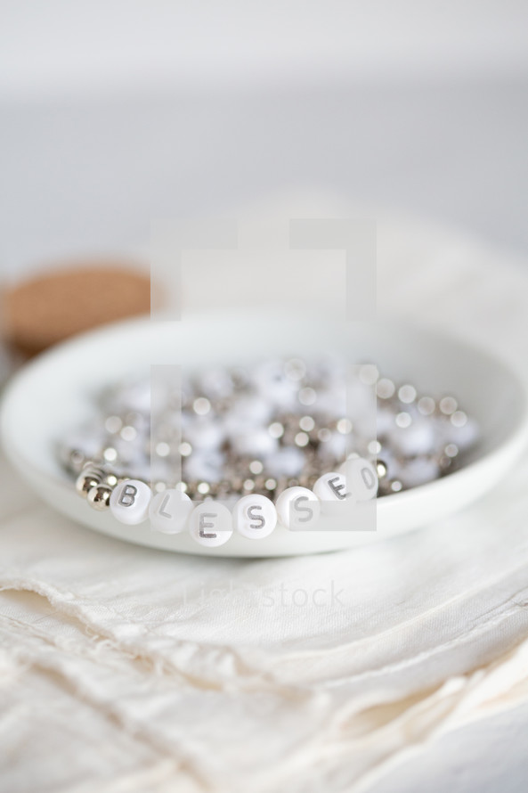 Close-up of white beads that spell out "blessed."