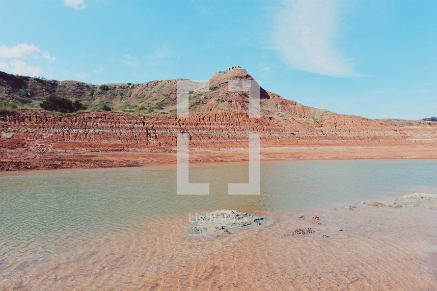 a lake and red rock cliffs