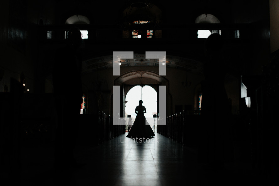 a silhouette of a bride standing in a doorway 