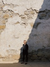 woman standing in front of a wall with exposed bricks 