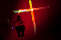 cross out of light in front of a man 