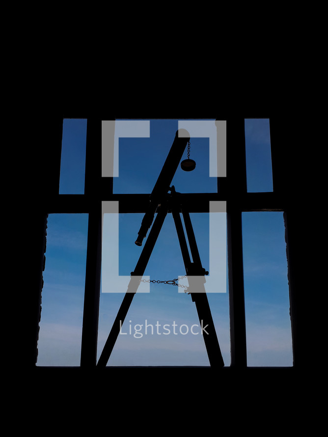 Telescope by the Window on a Blue Sky