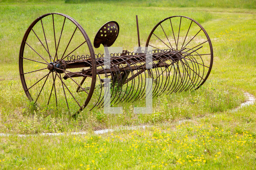Old farm equipment in grassy area