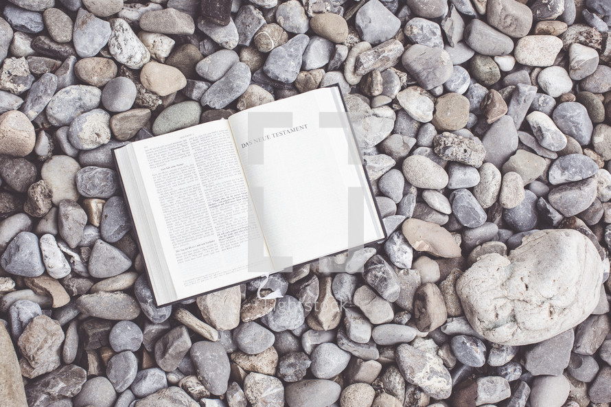 open Bible on pebbles 