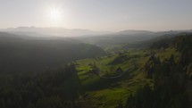 Aerial of forest, hills and mountains in sunset